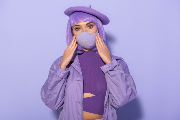 young woman dressed in doll style in medical mask and beret on violet colorful background - Fotó, kép