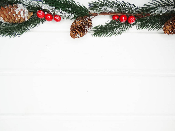 winter kerst achtergrond met sparren takken kegels en sneeuw op witte houten textuur                               - Foto, afbeelding