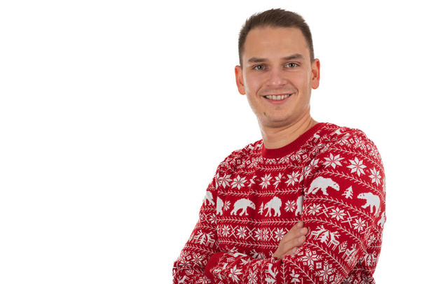 Portrait of handsome young man wearing christmas theme knitted blouse on isolated background - 写真・画像