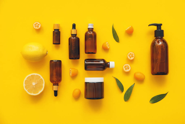 Složení lahví s přírodní citrusovou kosmetikou na barevném pozadí - Fotografie, Obrázek