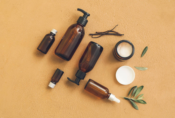 Composition of bottles with natural care cosmetics on color background - Photo, Image