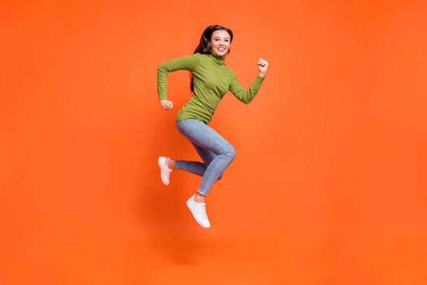 Full size profile sid photo of young active crazy girl have fun enjoy run jump happy smile isolated over orange color background - Foto, Imagen
