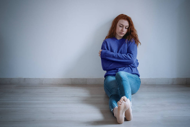 Chica joven deprimida en el suelo de parquet - Foto, imagen