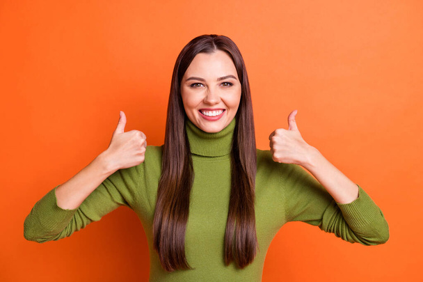 Photo of young attractive smiling cheerful beaming happy girl showing thumb-up isolated on orange color background - Zdjęcie, obraz