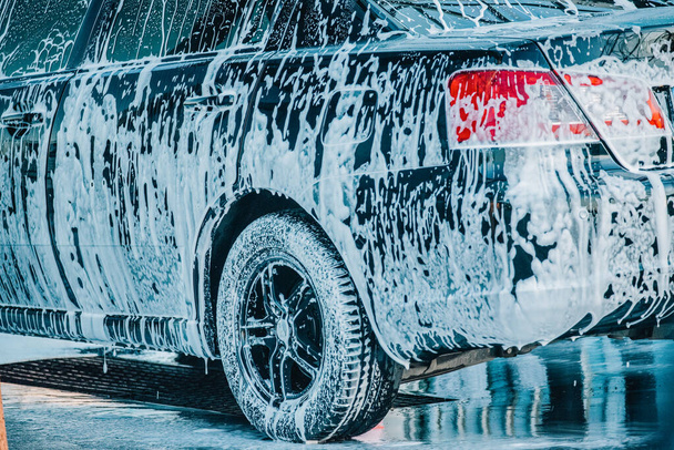 Das Auto waschen. Waschen eines schwarzen Autos in einer Waschanlage. Sauberes Auto - Foto, Bild
