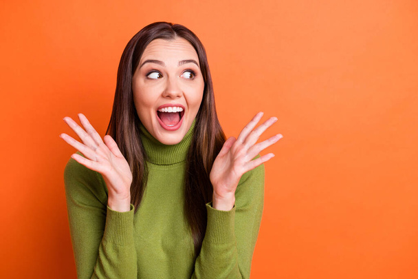 Portrait of young excited happy joyful smiling cheerful girl look copyspace hold hands isolated on orange color background - 写真・画像