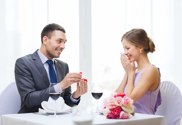 Man proposing to his girlfriend at restaurant - Фото, изображение