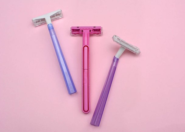 Layout of female disposable razors on a pink background. Closeup - Φωτογραφία, εικόνα
