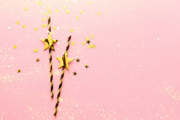 Pajitas de papel brillante con estrellas doradas fondo rosa pastel. Copiar espacio - Foto, Imagen