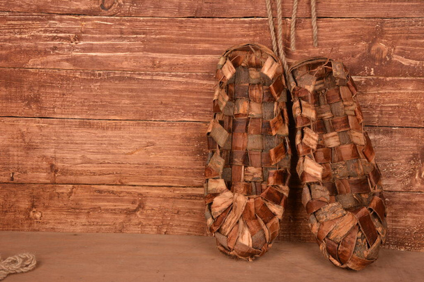 木製のフェンスに大きな靴。博物館ekskonat-古代のウィッカーの靴のコピー. - 写真・画像