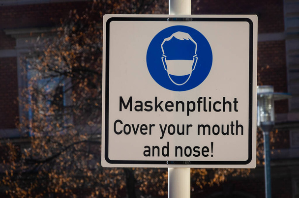signpost wear a mask in german and english language - Photo, Image