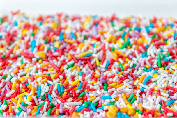 Muitos sprinkles coloridos como decoração deliciosa ou bolo de aniversário cobertura com doces doces polvilhados para dente doce e lanche insalubre para crianças como confecção gostosa para donuts e bolos de arco-íris - Foto, Imagem