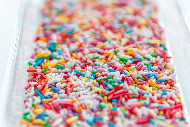 Many colorful sprinkles as delicious decoration or birthday cake topping with sweet candy sprinkles for sweet tooth and unhealthy snack for children as yummy confection for donuts and rainbow cakes - Photo, Image