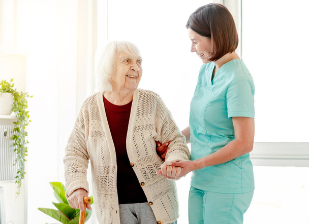 Caregiver helping elderly woman to walk - Valokuva, kuva