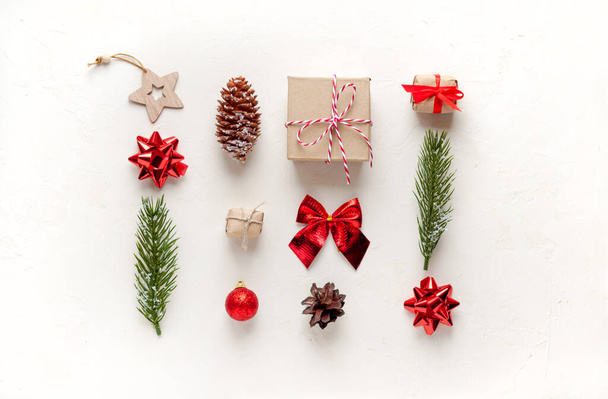 Χριστουγεννιάτικα δέντρα ξύλινα παιχνίδια, έλατα κλαδιά, κώνοι .τόξο σε λευκό φόντο Η έννοια των Χριστουγέννων και του νέου έτους. - Φωτογραφία, εικόνα