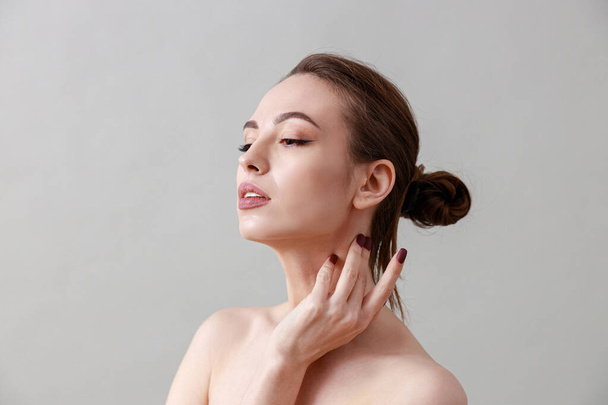 Studio beauty portrait of a young, healthy, beautiful, fresh skinned caucasian woman on a grey background - Zdjęcie, obraz