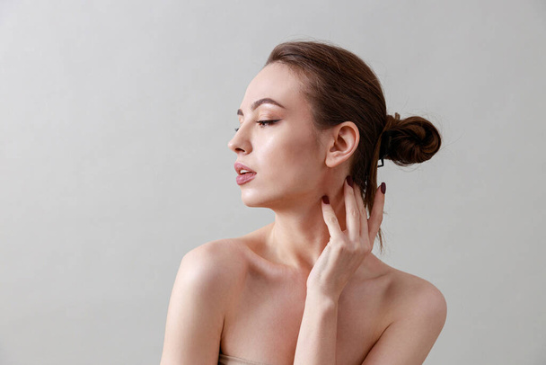 Studio beauty portrait of a young, healthy, beautiful, fresh skinned caucasian woman on a grey background - Фото, зображення