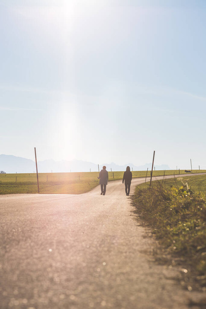Dos personas caminan por un camino abandonado - Foto, Imagen