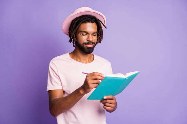 Photo of young afro handsome happy smiling positive man male guy hold write blue diary isolated on purple color background - Foto, immagini