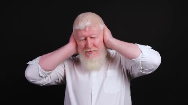 Primo piano di un albino che copre le orecchie con le mani, annuendo. - Filmati, video