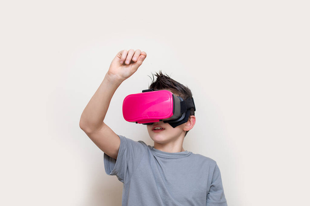 仮想現実シミュレータの眼鏡の少年ティーンエイジャーは、仮想空間に書き込み、オンライン教育や演劇を受信します。デジタル技術の助けを借りて現代の教育。写真 - 写真・画像