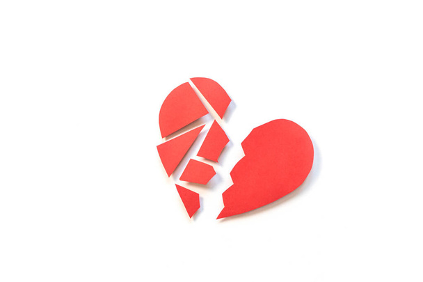 Punainen paperi sydän leikattu kahtia. Käsitteen yksipuolinen rakkaus, erottaminen, avioero, särkynyt sydän. Minimalismi, paperitaide. - Valokuva, kuva