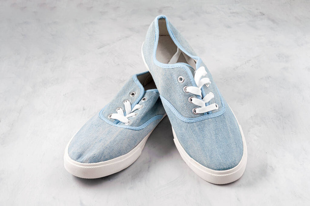 pair blue fabric stylish sneakers with laces on grey textured background - Foto, Imagem