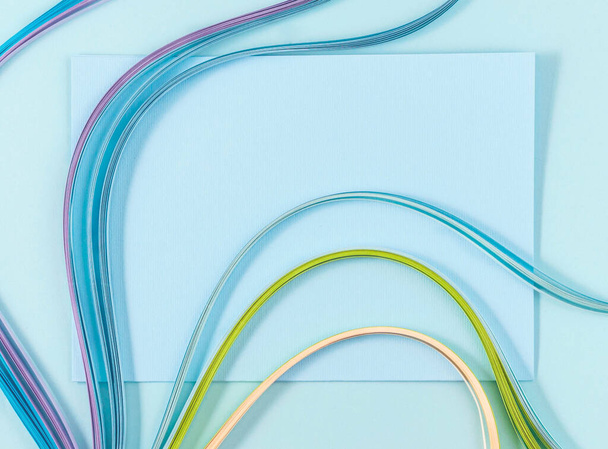 top view of colorful wavy paper lines on blue background - Fotoğraf, Görsel