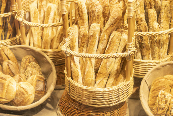 A top view closeup of french baguette loaves of bread in a basket at the store - Foto, Imagem