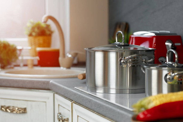 Still life photo of metal casseroles on induction stove in kitchen - Photo, image