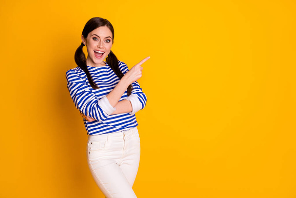 Portrait of positive cheerful excited girl promoter point index finger copyspace recommend suggest select ads promo wear good look clothes isolated bright color background - Photo, image