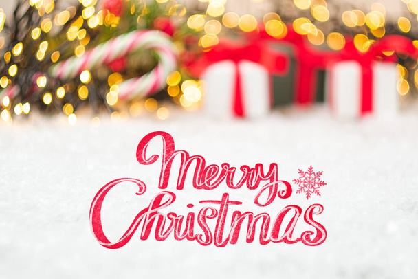 Tarjeta de felicitación de Feliz Navidad con cajas de regalo y cinta roja en la nieve. - Foto, imagen