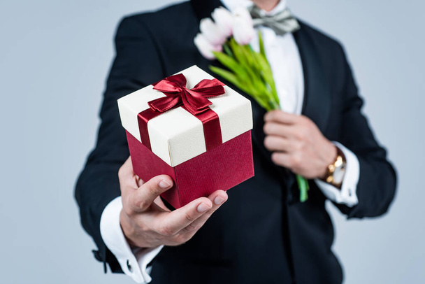 Shop the stores for gift ideas. Present box in male hands. Gift shop. Floral arrangement. Holiday celebration. Festive occasion - Foto, Imagem