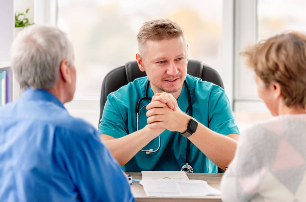 Physician talking to mature couple in cabinet - Photo, image