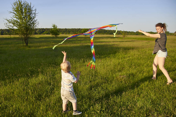 Mãe com seu filho pequeno voar um papagaio no prado, o tema da diversão de verão. - Foto, Imagem