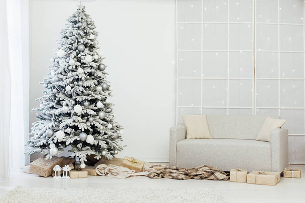 Интерьер дома. Комната с красивой снежной елкой и подарками под этой елкой. - Фото, изображение