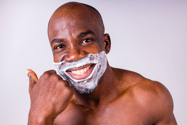 latin hispanic man with razor and shaving foam on his face studio white isolate background - Fotoğraf, Görsel