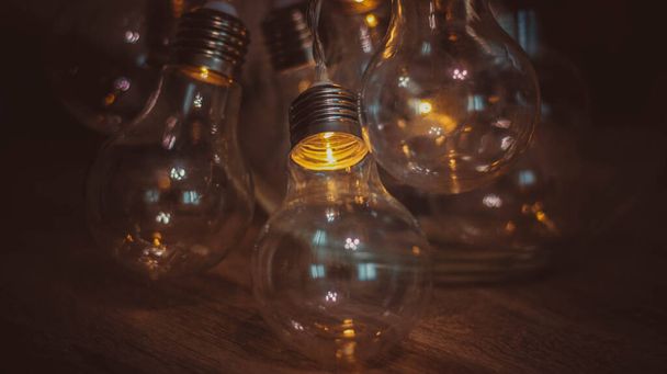 Guirnaldas eléctricas en forma de bombilla brillan en la oscuridad - Foto, imagen