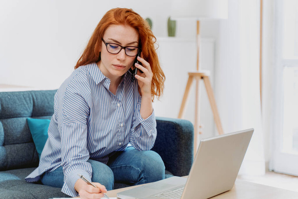 Kobieta pracująca w domu za pomocą laptopa i połączenia internetowego - Zdjęcie, obraz