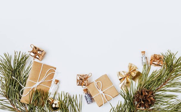 New year golden gifts for merry christmas with fir branches on white background - 写真・画像