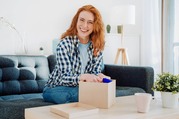 Woman unboxing just delivered item after home shopping - Foto, Bild