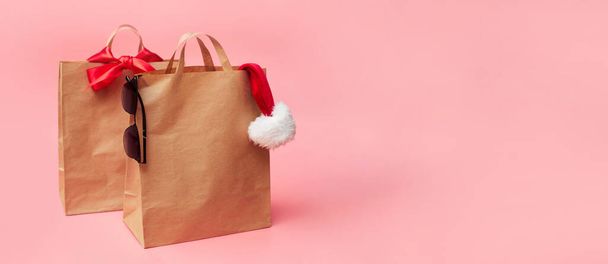 concetto di Natale, due borse di carta artigianale, sconti sugli accessori, su sfondo rosa, banner, spazio copia, mock up - Foto, immagini