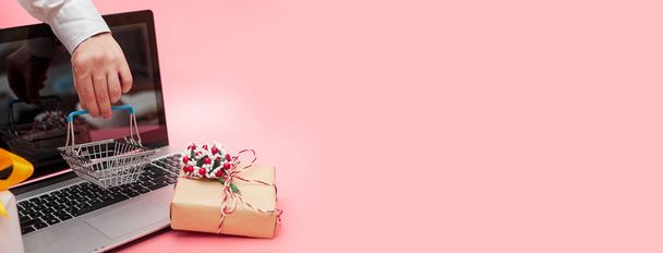 marketing en ligne, ordinateur portable concept krismas avec des cadeaux, sur fond rose, bannière, espace de copie - Photo, image