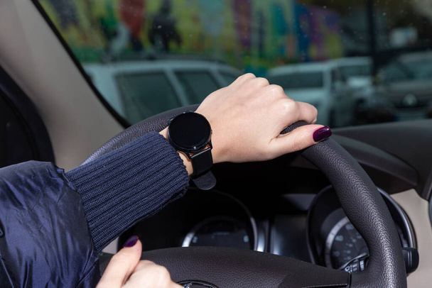 Ręka kobiety trzyma kierownicę, zegarek jest na jego ręce, Galaxy Watch3 - Zdjęcie, obraz