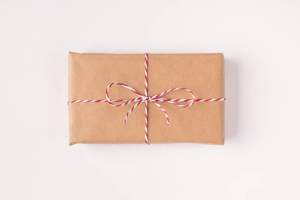 Closeup top above overhead flatlay view photo of one single present box wrapped in eco kraft paper isolated white color background - Photo, Image