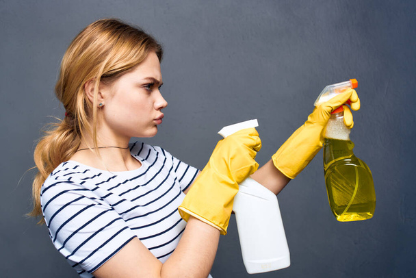 Senhora limpeza emocional com detergente nas mãos do serviço de cuidados em casa, tornando fundo cinza interior - Foto, Imagem