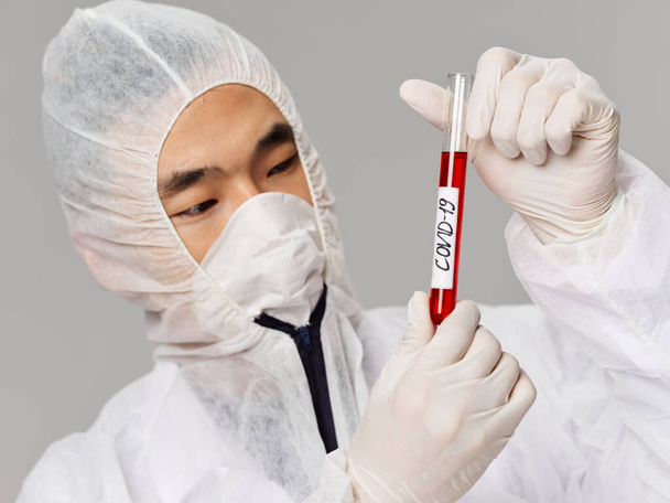 Человек азиатского вида лабораторная защита анализирует лечение тестирования - Фото, изображение