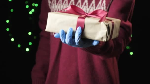 παιδικό χέρι δίνοντας κόκκινο κουτί με λευκή κορδέλα. Χριστούγεννα, το νέο έτος έννοια - Πλάνα, βίντεο