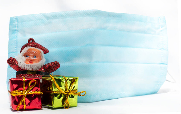 Boldog Karácsonyt Mikulás ajándékdobozok és kék maszk elleni védelem koronavírus - Fotó, kép