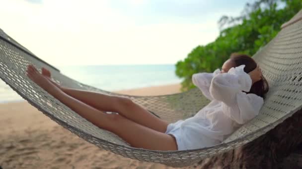 съемка красивой азиатской женщины, отдыхающей на берегу моря во время летних каникул - Кадры, видео